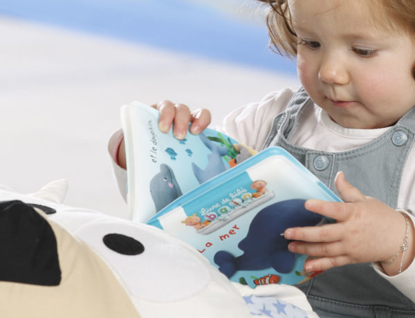 bébé qui tient et regarde un livre sur le coussin animal blog wesco