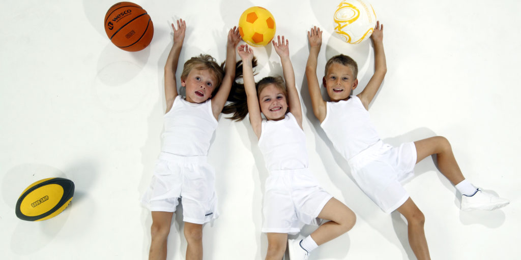 enfants allongés sur le sol habillé en blanc entourés de ballons sport blog wesco