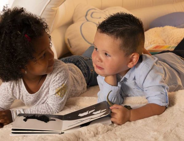 deux enfants sur tapis qui regardent un livre ensemble habiletés sociales blog wesco