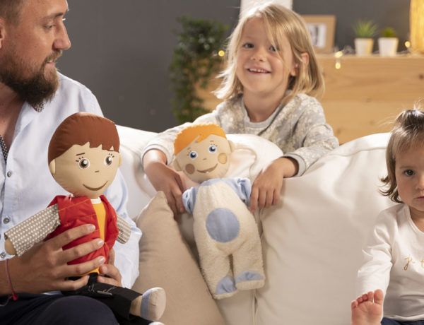 adulte avec deux enfants assis sur un canapé avec poupées blog wesco