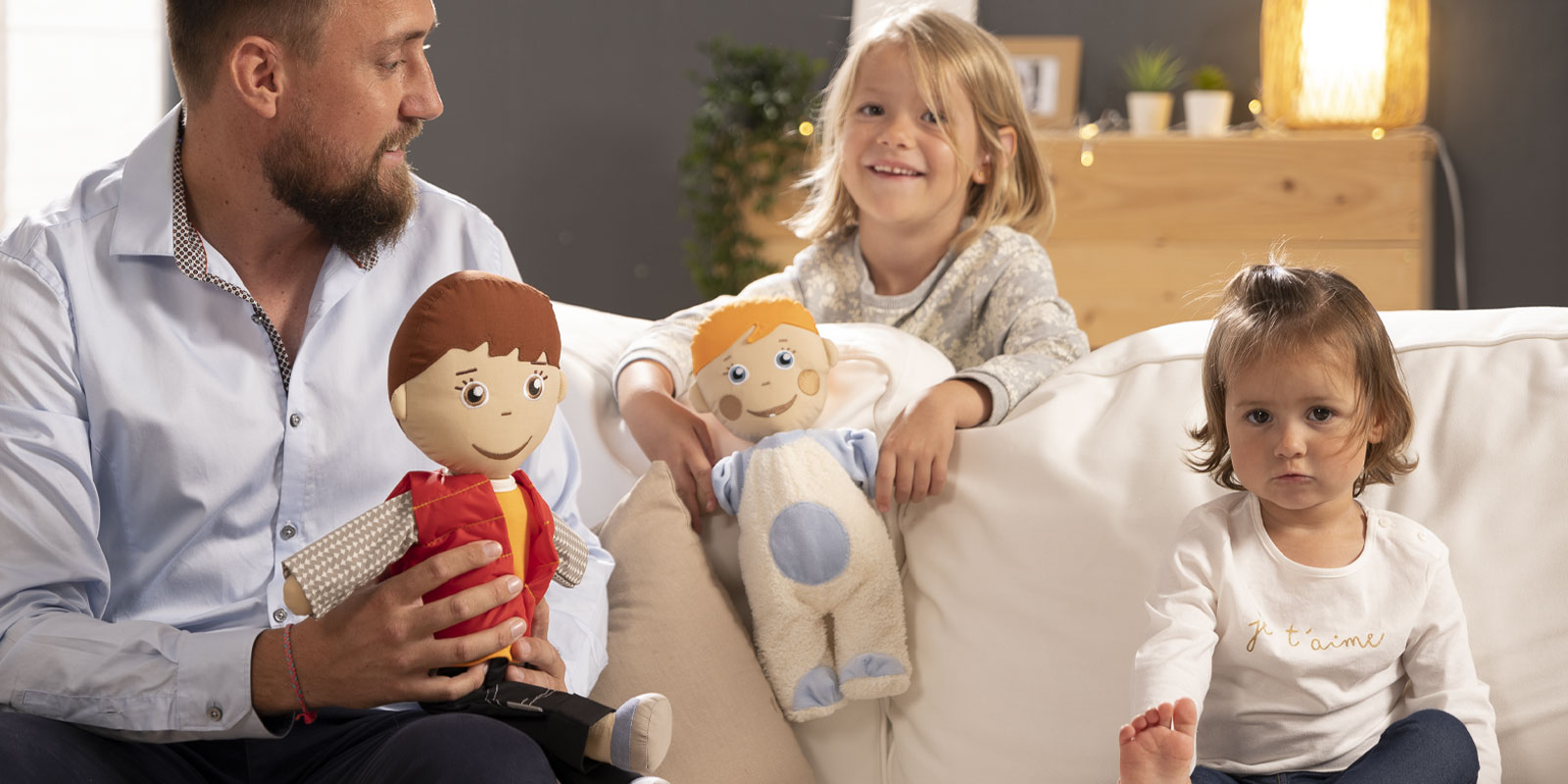 adulte avec deux enfants assis sur un canapé avec poupées blog wesco