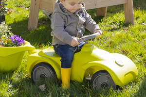 Enfant dehors qui joue avec une voiture blog wesco