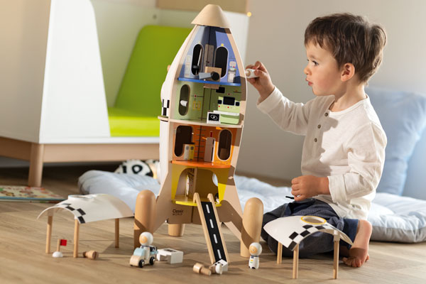 Enfant qui joue avec une fusée en bois blog wesco